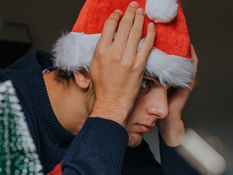 Mann mit Nikolausmütze schlägt die Hände über dem Kopf zusammen