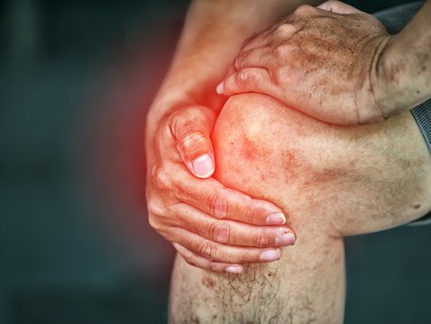 Hand greift um schmerzendes Knie 