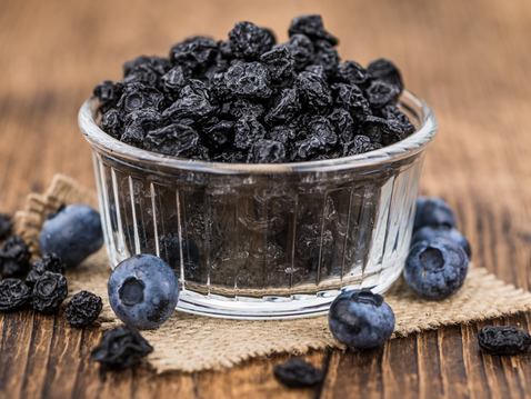 Getrocknete Heidelbeeren in Schale auf Holztisch